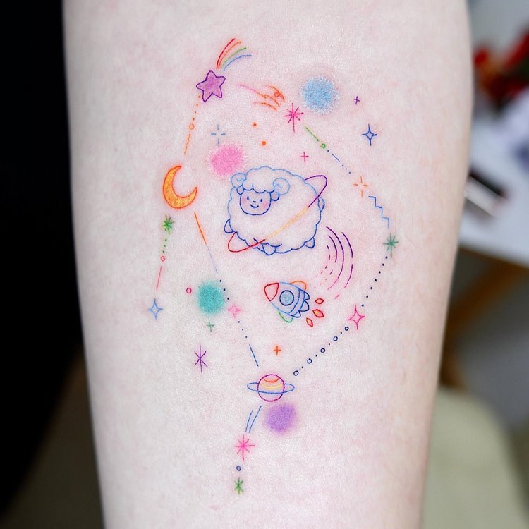 Tattoo de constelação do signo de Capricórnio, cores: rosa, vermelho, amarelo, verde, azul, lilás, laranja, roxo, estilo aquarela. Com desenhos de foguete, planetas, lua, ovelha