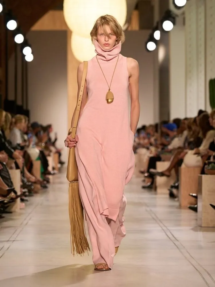Foto de modelo usando vestido rosa claro e maxi colar Michael Kors SS 26