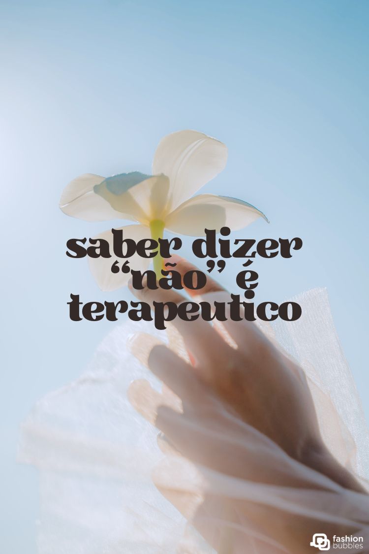 A imagem apresenta uma mão estendida suavemente em direção a uma flor branca delicada no canto superior esquerdo, contra um céu azul claro e suave. A frase "saber dizer 'não' é terapêutico" está centralizada. A foto evoca paz, autocuidado e limites saudáveis.