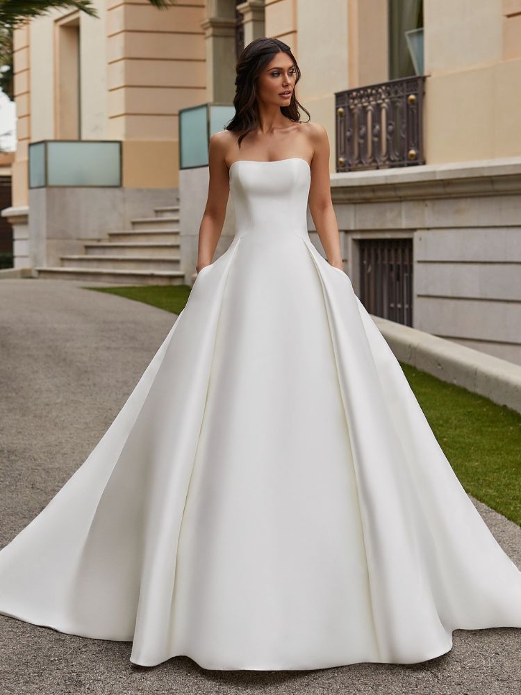 Mulher de pele clara usando vestido minimalista tomara que caia, com corselet e saia sem bordados e de cortes retos