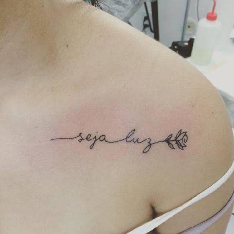 Tatuagem "seja luz" no ombro com flor 