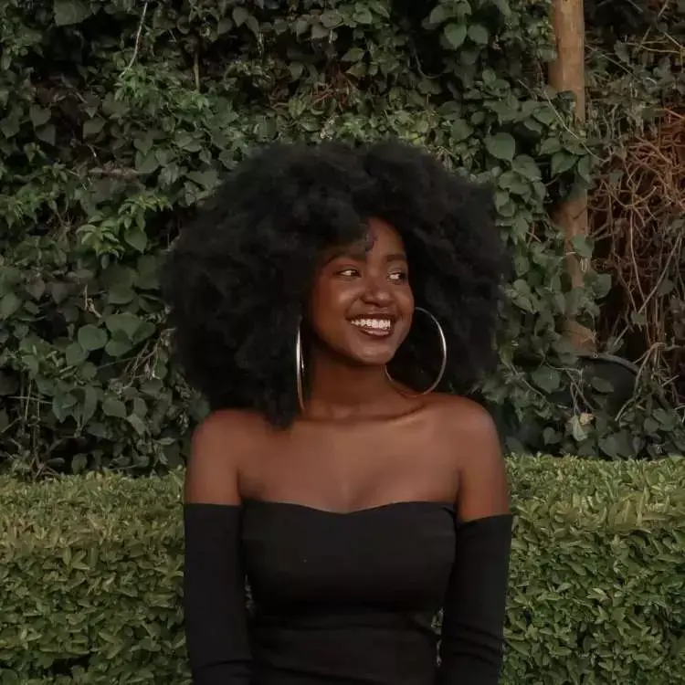 Mulher com corte de cabelo médio crespo franja irregular