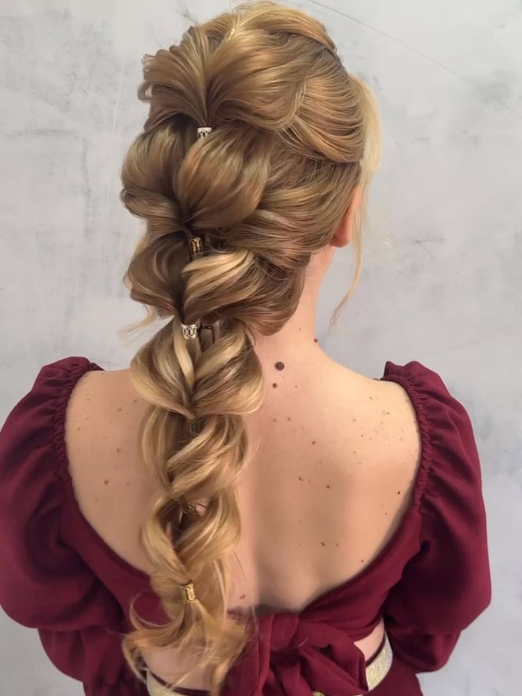 Mulher de pele clara de costas usando trança falsa no cabelo longo loiro