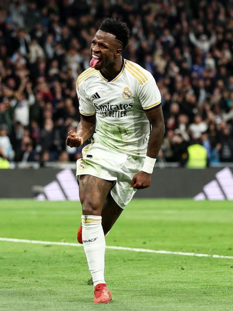 Vini Jr com a camisa do Real Madrid comemorando um gol