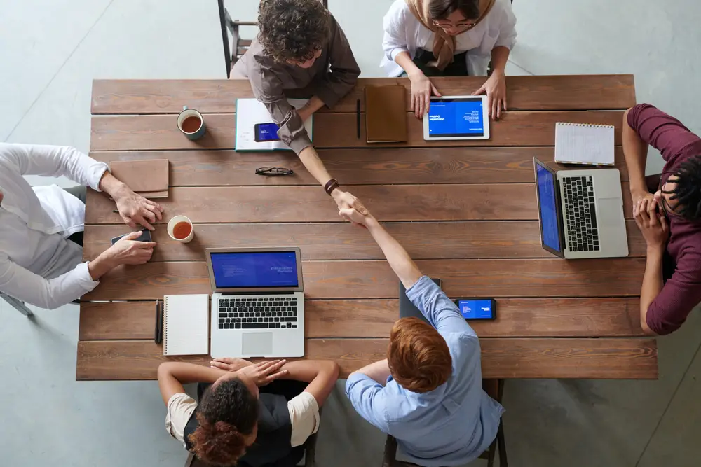 pessoas trabalhando em computadores numa mesa Tecnologia 5G