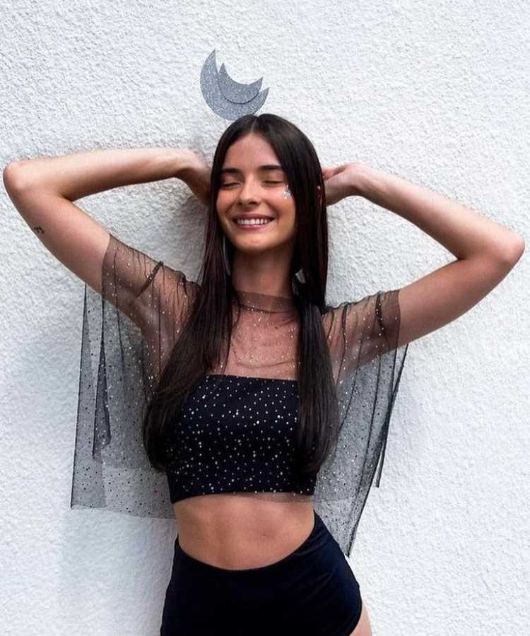 Jovem com fantasia e tiara de lua para o Carnaval.