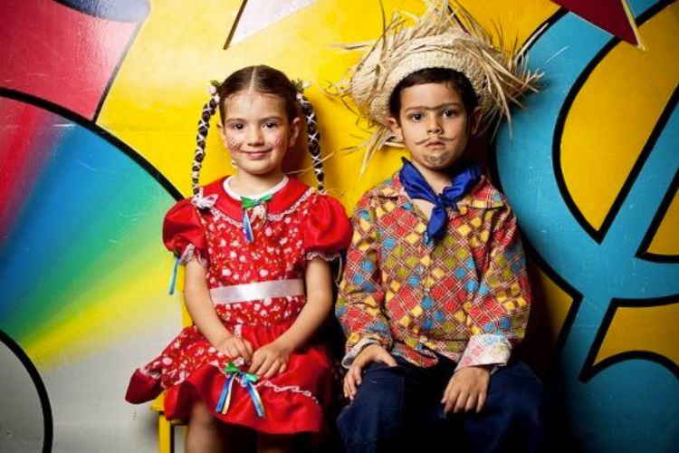 menina e menino com look de festa junina