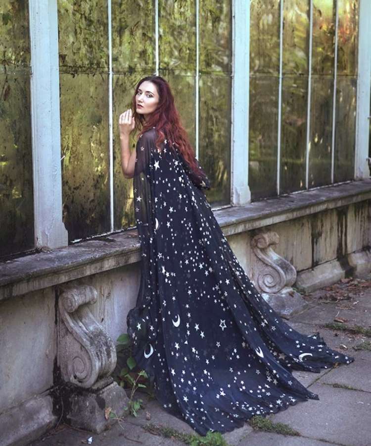 Mulher com capa longa de estrela e lua