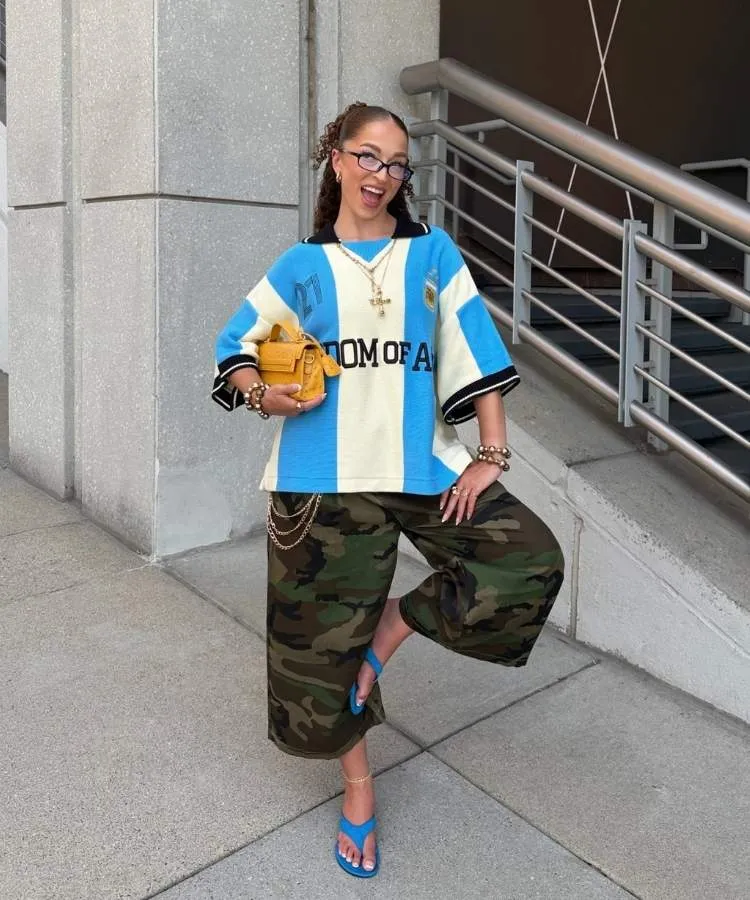 Mulher usando camisa de time e bermuda com estampa camuflada