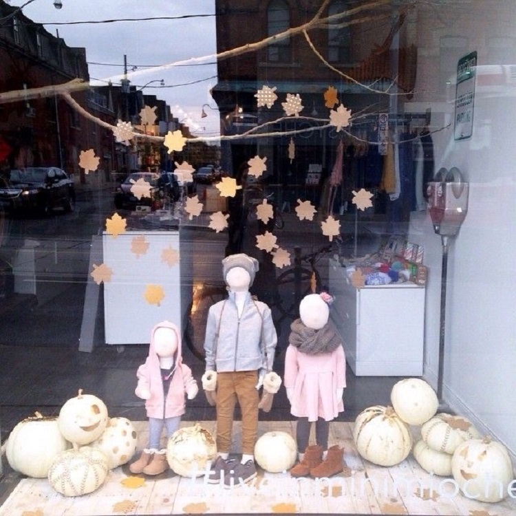Vitrine simples infantil para o Halloween, com roupas de criança, abóboras e folhas de outono
