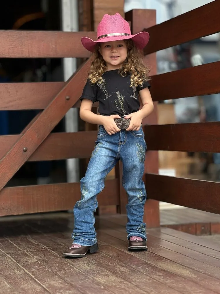Menina de pele clara de chapéu country rosa, camiseta preta de cactos, calça jeans, bota 