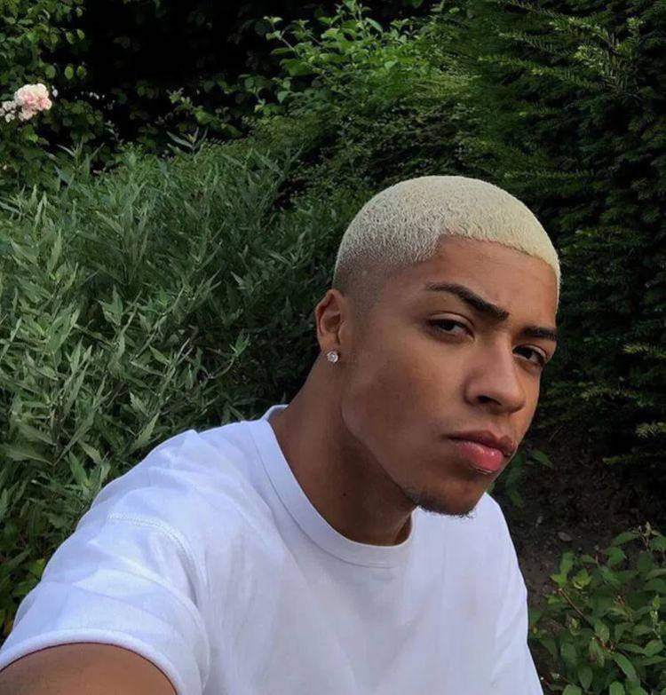 Homem de pele morena com cabelo platinado curto