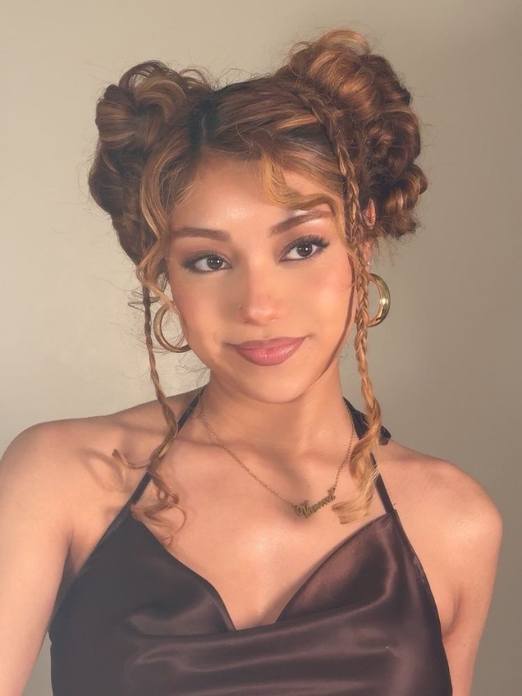 Mulher de pele morena com cabelo castanho em space buns