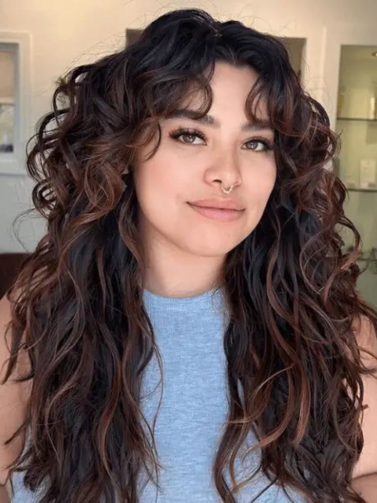 Mulher de pele clara usando cabelo cacheado em shaggy 