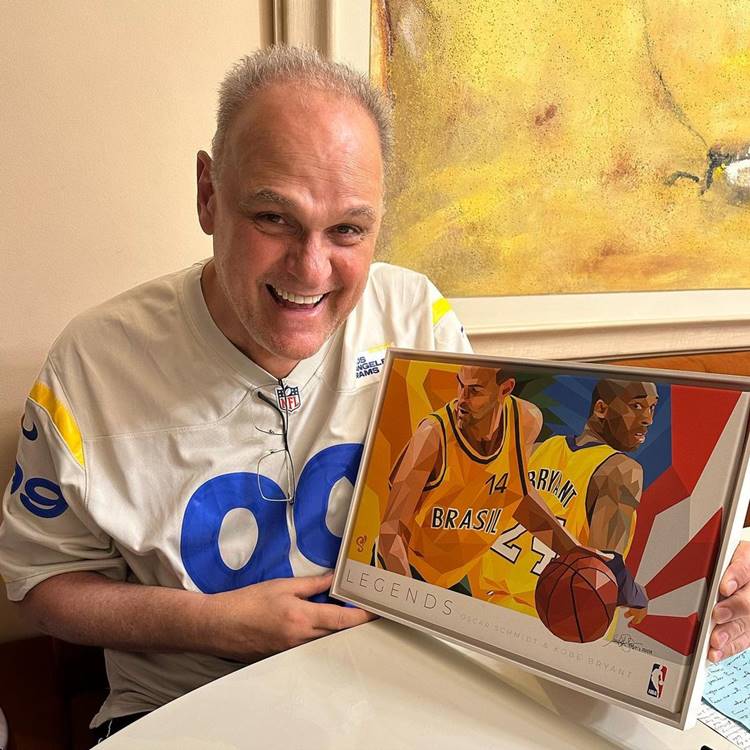 O ex-jogador de basquete segurando obra de arte em sua homenagem.