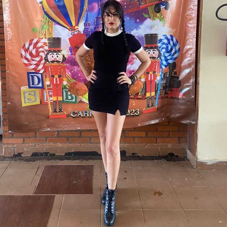 Mulher com fantasia de Wandinha, personagem de série da Netflix, para o Carnaval.
