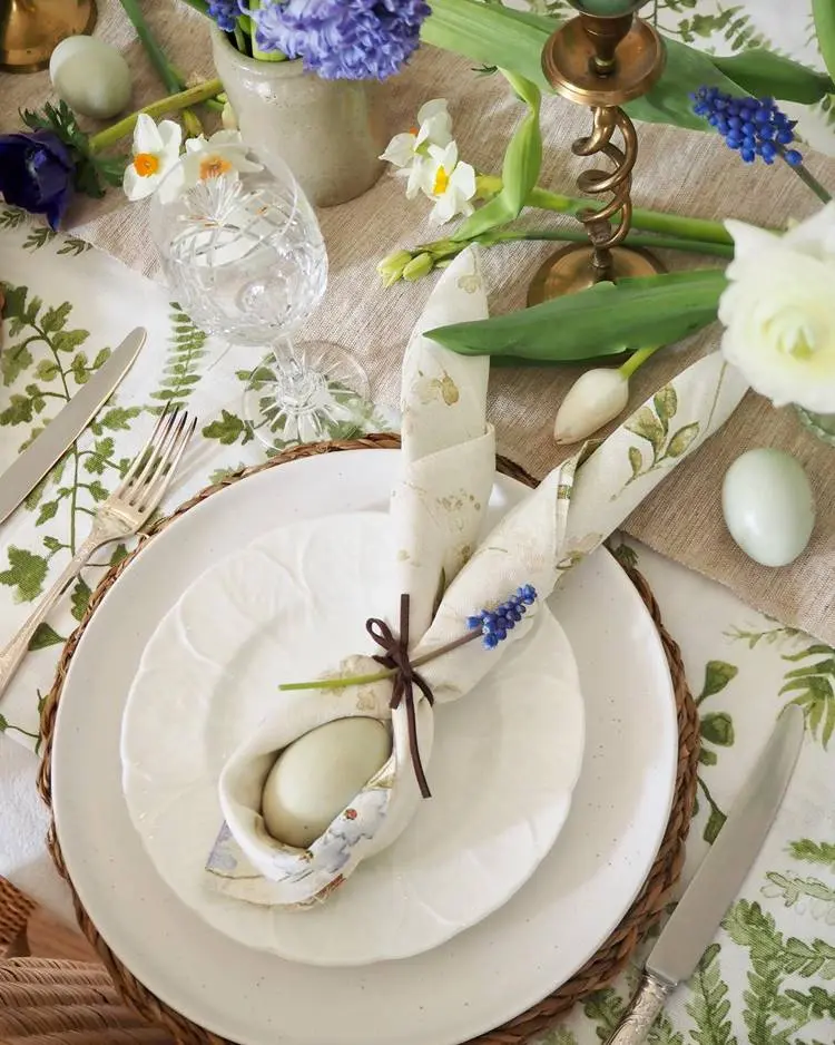  prato em mesa posta com guardanapo decorativo em formato de orelhas de coelho
