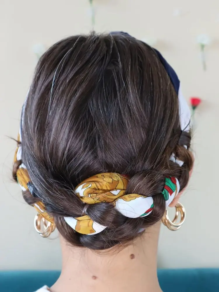 Mulher de pele clara de costas usando cabelo castanho em coque trança com lenço