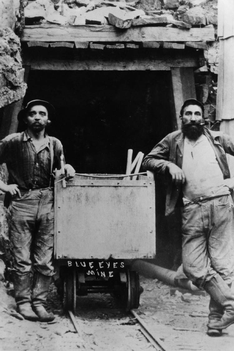 Foto em preto e branco de trabalhadores em mina usando jeans