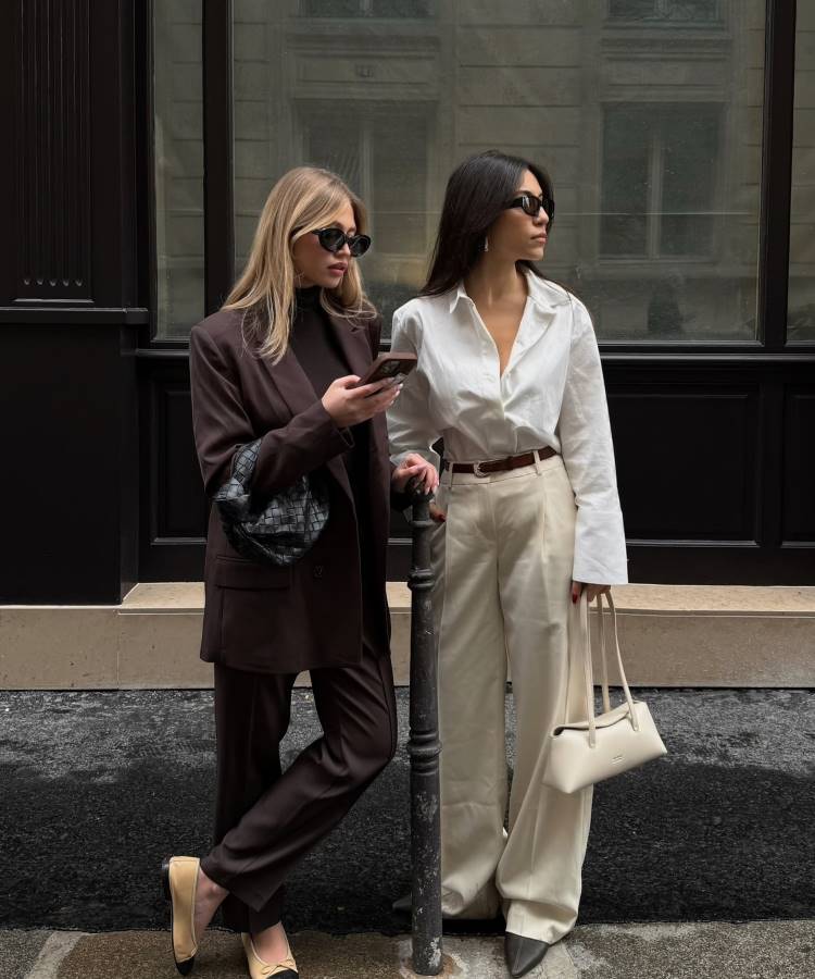 Duas mulheres elegantes posam em rua urbana. À esquerda, look em terno marrom oversized com bolsa preta e sapatilhas bege. À direita, camisa branca e calça off-white ampla com bolsa estruturada. Inspiração perfeita para looks de trabalho modernos e sofisticados.



Duas mulheres elegantes posam em rua urbana. À esquerda, look em terno marrom oversized com bolsa preta e sapatilhas bege. À direita, camisa branca e calça off-white ampla com bolsa estruturada. Inspiração perfeita para looks de trabalho modernos e sofisticados.







