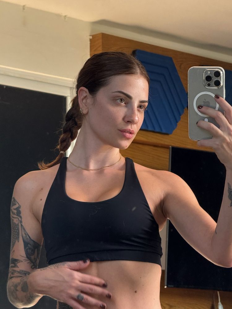 Mulher de pele clara de top preto e trancinha simples 