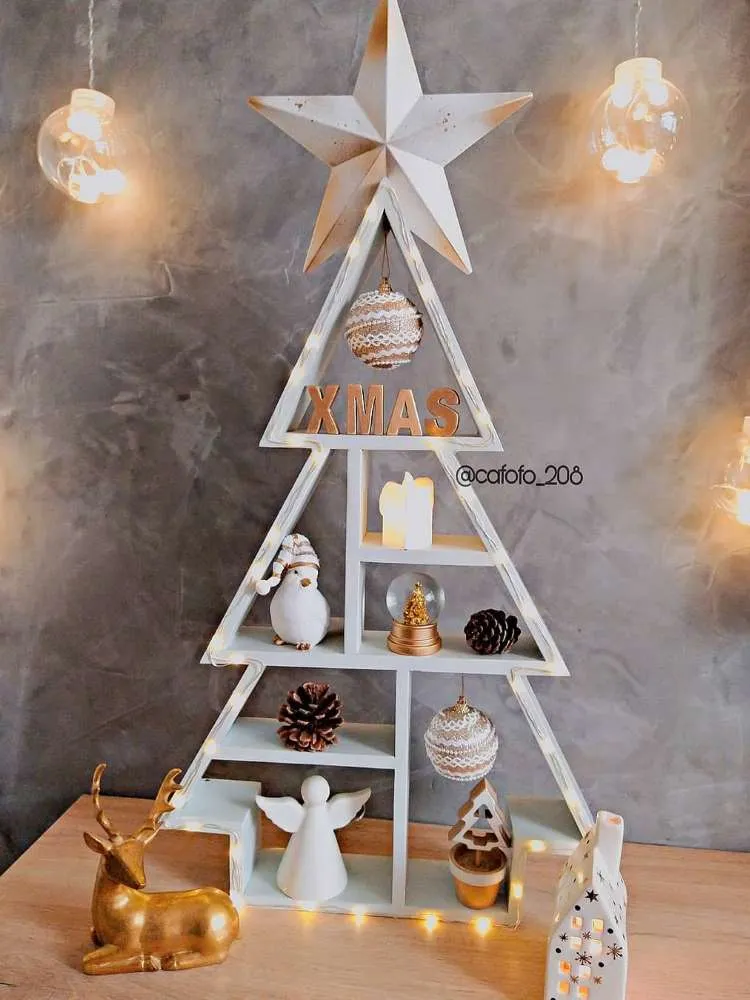 Árvore de Natal em madeira pintada de branco com enfeites brancos e dourados.