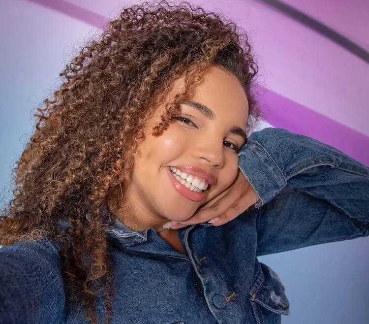 Selfie de Giovanna Marinho (Pitel), da Pipoca do BBB 24, sorrindo usando blusa de manga longa jeans