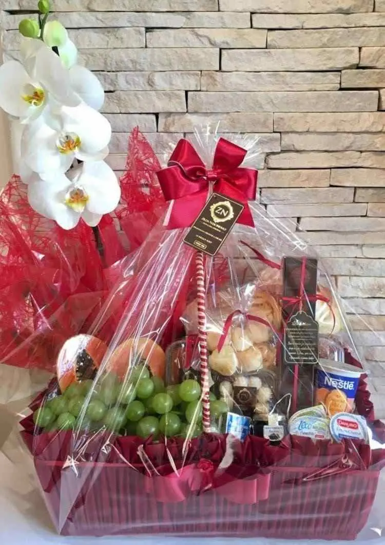 cesta vermelha com frutas, iogurte e guloseimas