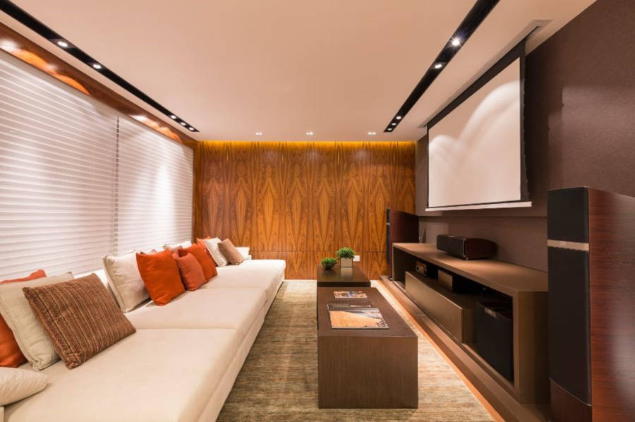 Sala de tv com cortina blackout e tela que desce do teto.