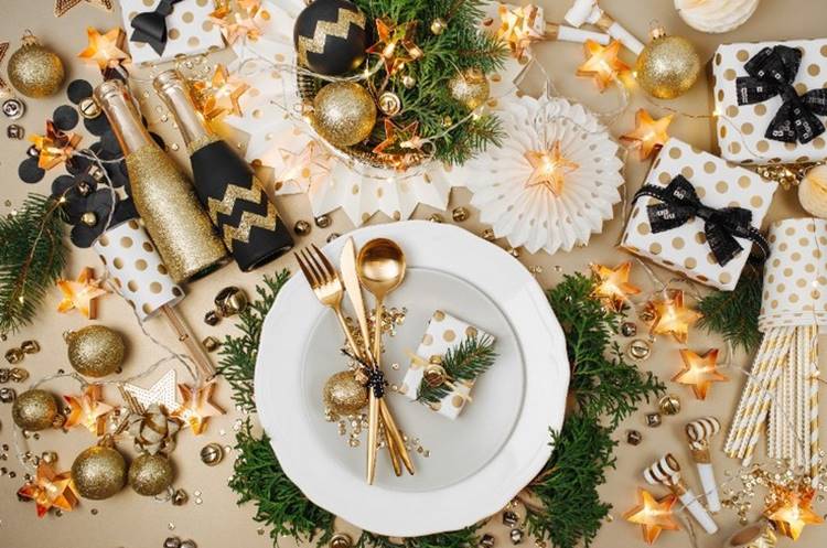 Decoração de mesa para o ano novo com garrafas, pratos, talheres, luzes e bolas. Foto de mesa decorada para o ano novo.