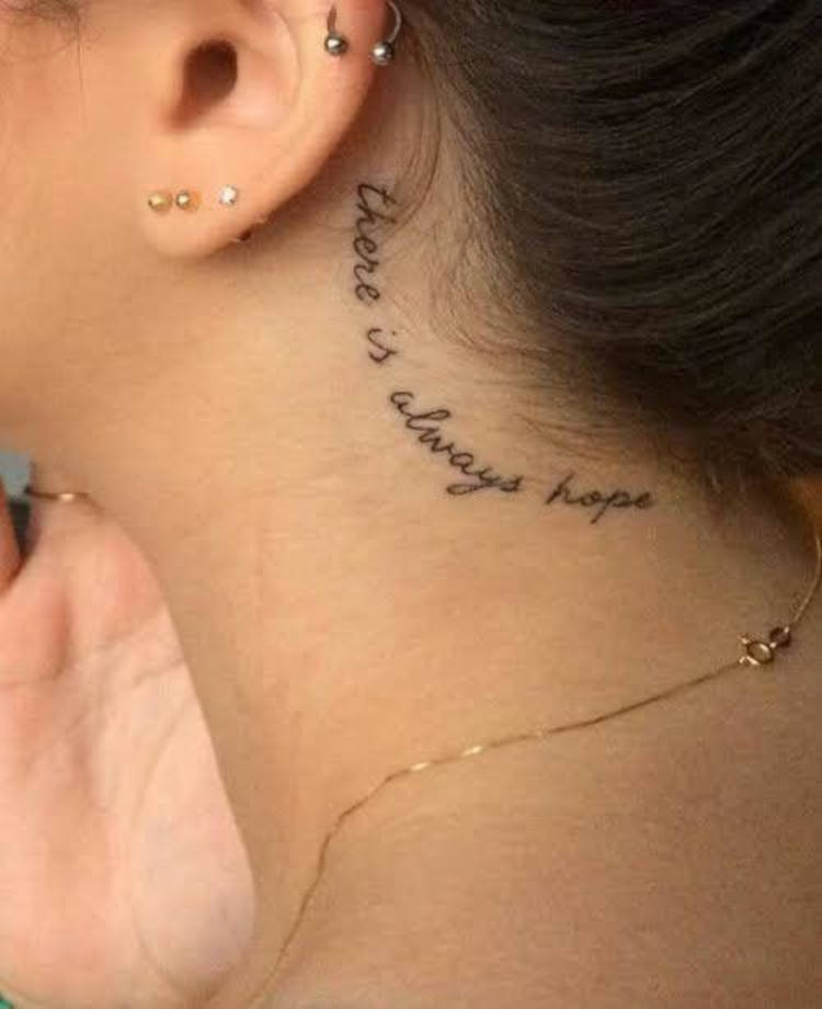Tattoo atrás da orelha escrito "there is always hope"