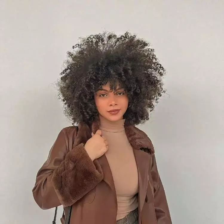Mulher com corte de cabelo médio crespo franja assimétrica