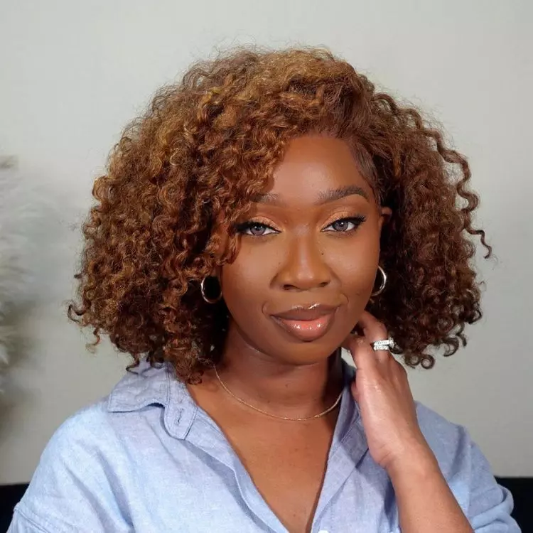 Mulher de pele negra usando camisa azul e cabelo chanel ondulado 