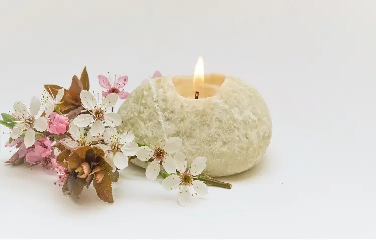 vela acesa ao lado de flores de cerejeira ritual para prosperidade na Páscoa