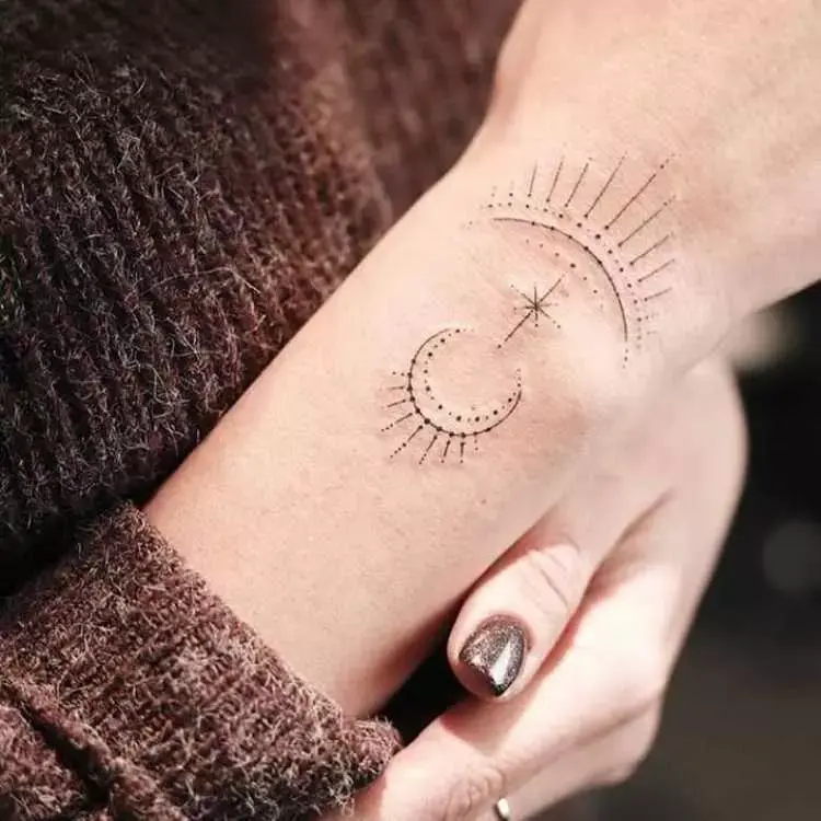 tatuagem parte superior do pulso, pontilhado de lua e raios de luz