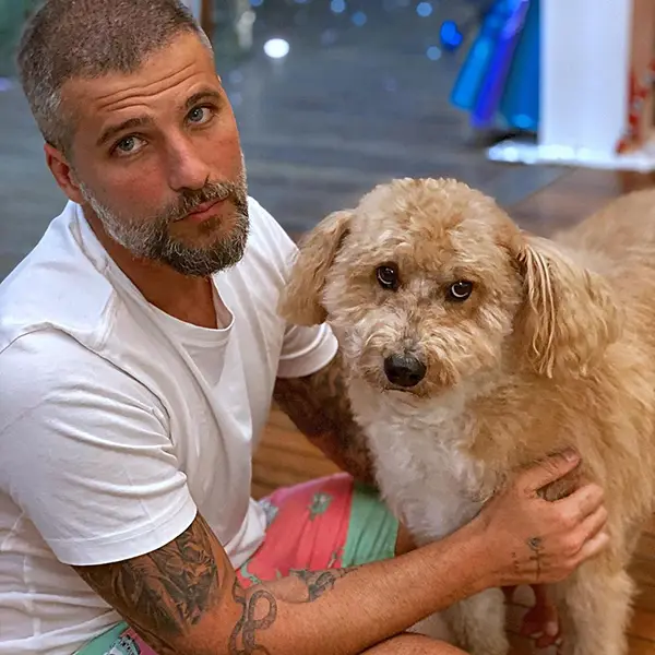 Bruno Gagliasso de roupa branca ao lado de poodle bege