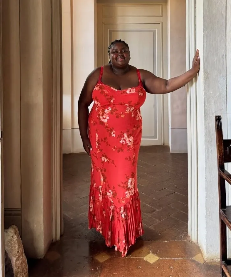 Foto da influencer Abisola Omole usando vestido vermelho para o Natal com estampa floral