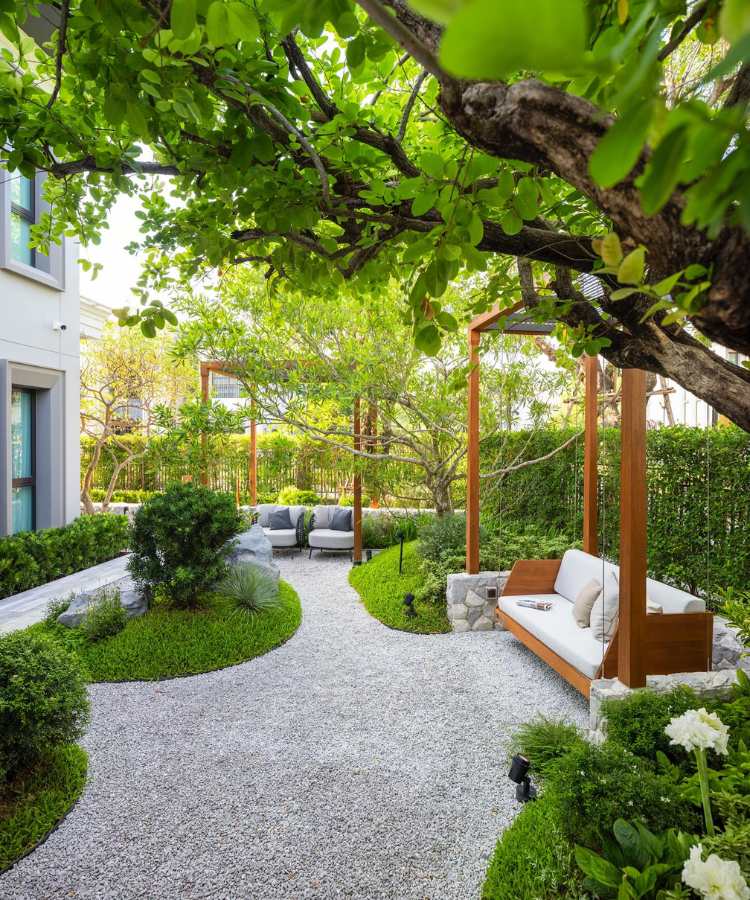 Jardim luxuoso com pedras e banco de madeira