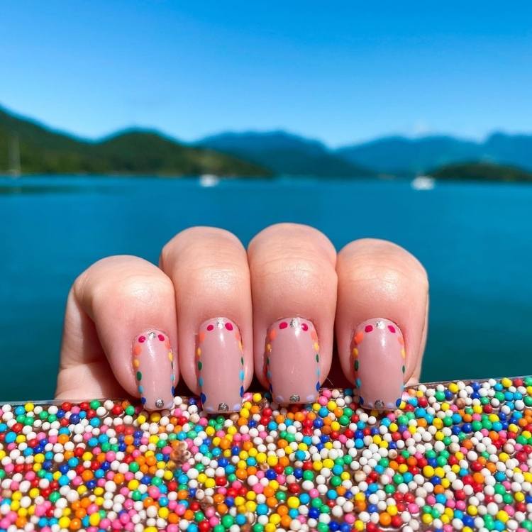 Foto unha com bolinhas coloridas.