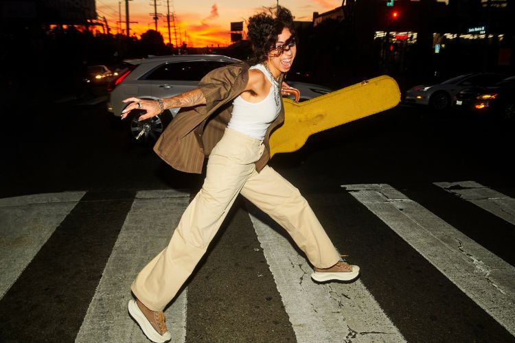 mulher usando regata branca, camisa marrom, calça cáqui e tênis Chuck 70 AT-CX