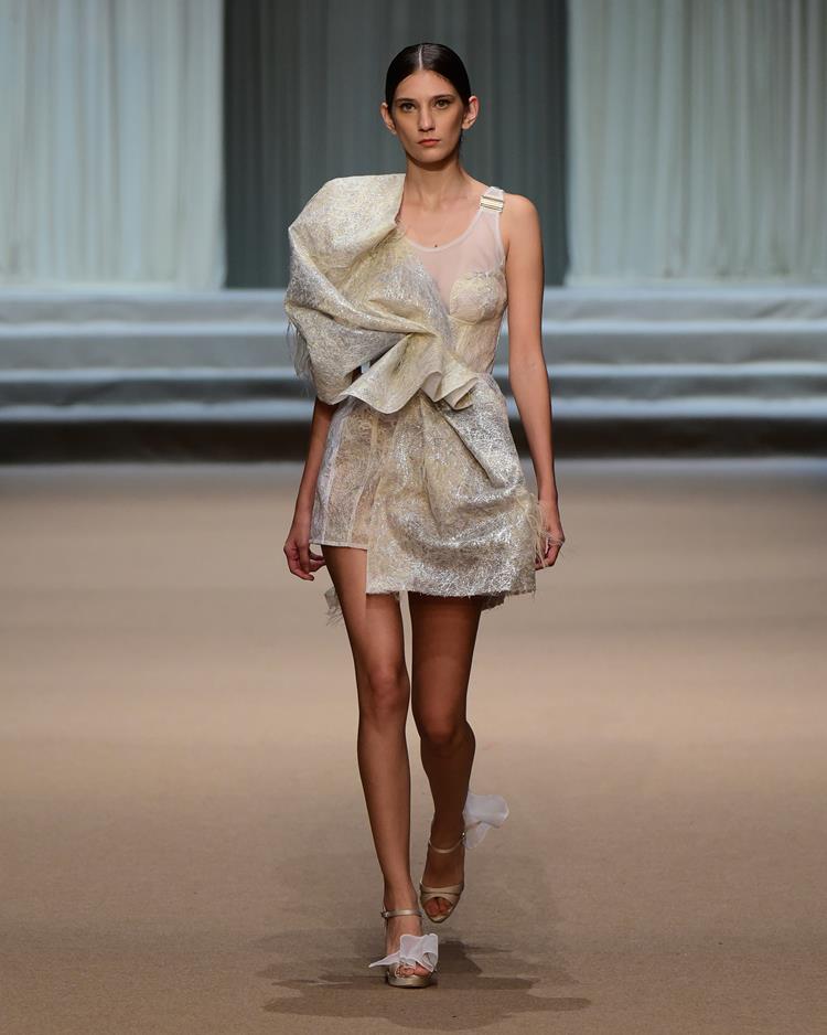 modelo no desfile Melk Z-Da com vestido curto branco e dourado