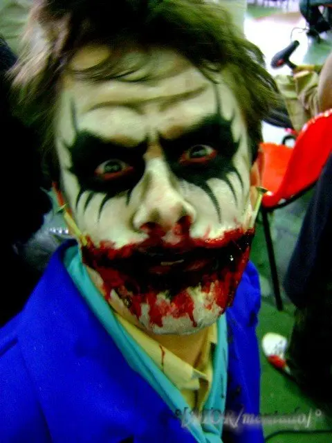 Maquiagem para o Halloween: caveira Homem usando maquiagem de Coringa com boca ensanguentada