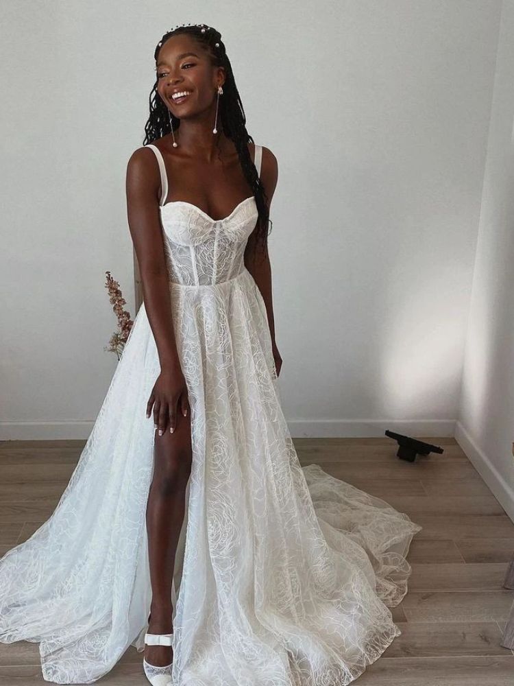 Mulher de pele negra usando vestido de noiva com corselet, alcinhas e saia bordada