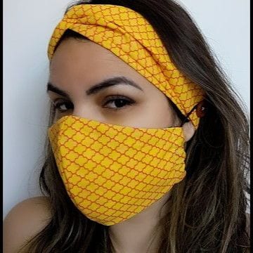 Foto de mulher usando mascara de proteção e tiara com o mesmo tecido