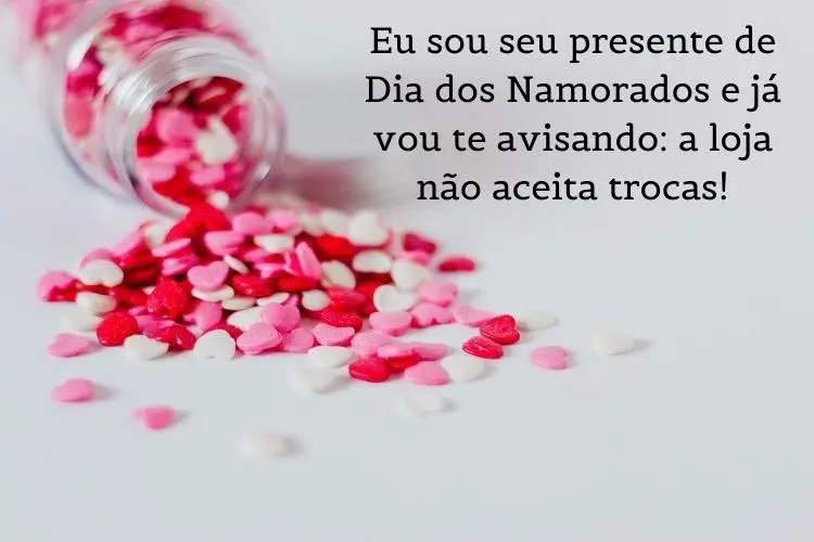 Foto de frasco transparente caído com corações brancos, rosas e vermelhos saindo dele, além de frase "Eu sou seu presente de Dia dos Namorados e já vou te avisando: a loja não aceita trocas!"