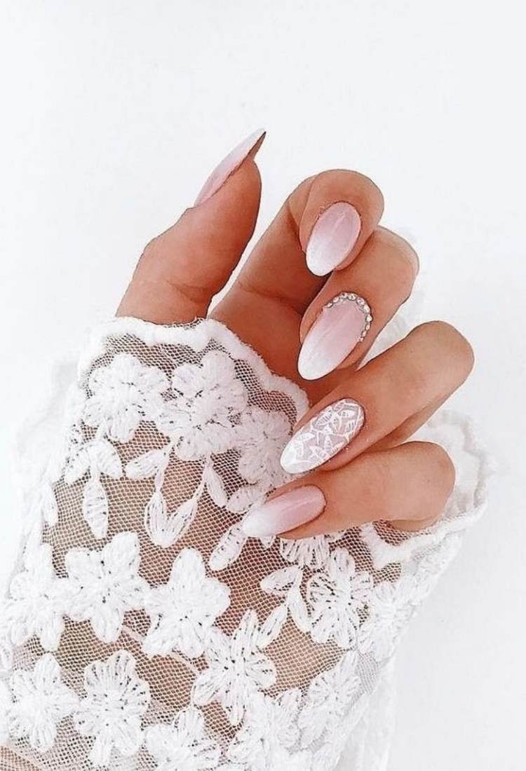 Unhas almond babyboomer, com pedrarias e desenhos brancos de flores
