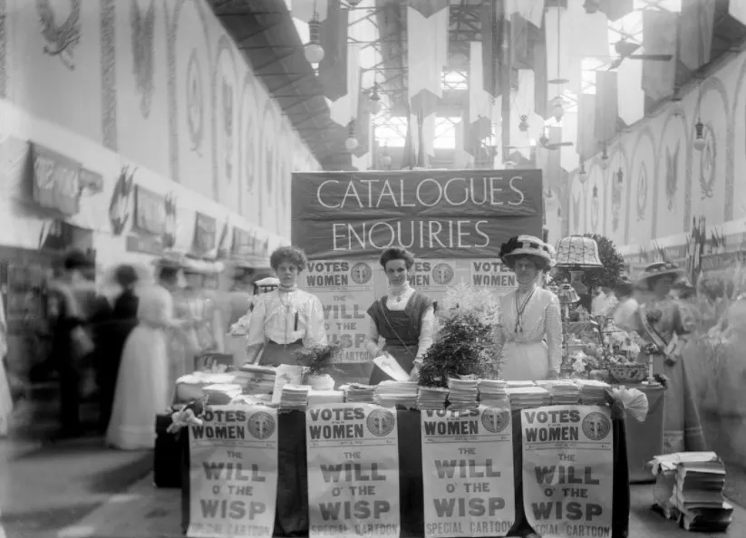 Foto em preto e branco de Sufragistas na "Exibição das Mulheres" em 1909 Sufragistas na "Exibição das Mulheres", em 1909 em Londres, a discutir a moda e a cidadania feminina.