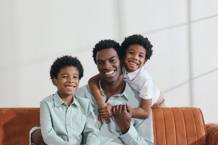 Foto de pai com seus dois filhos em campanha da C&A