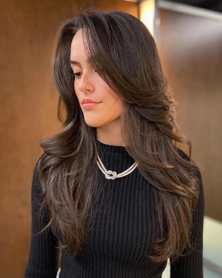 mulher com cabelo longo castanho e franja média