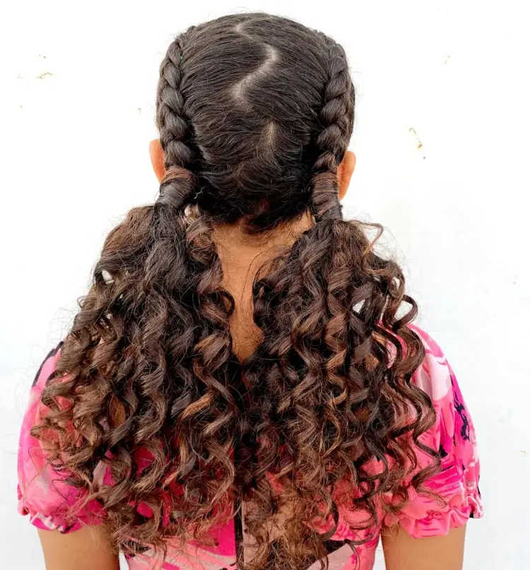 cabelo cacheado castanho escuro preso em dois rabos baixos.